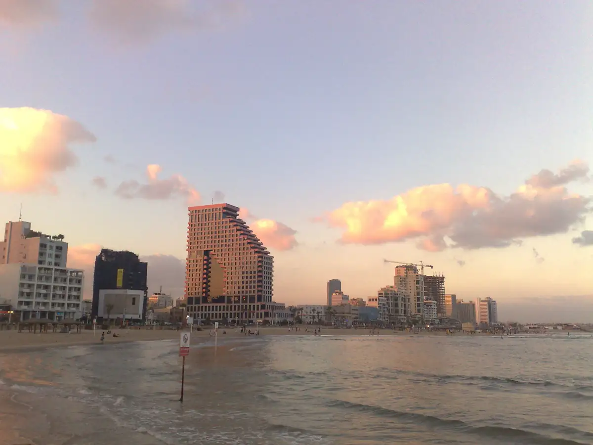 The Tel Aviv beach at dawn, the hotel towers under pink clouds