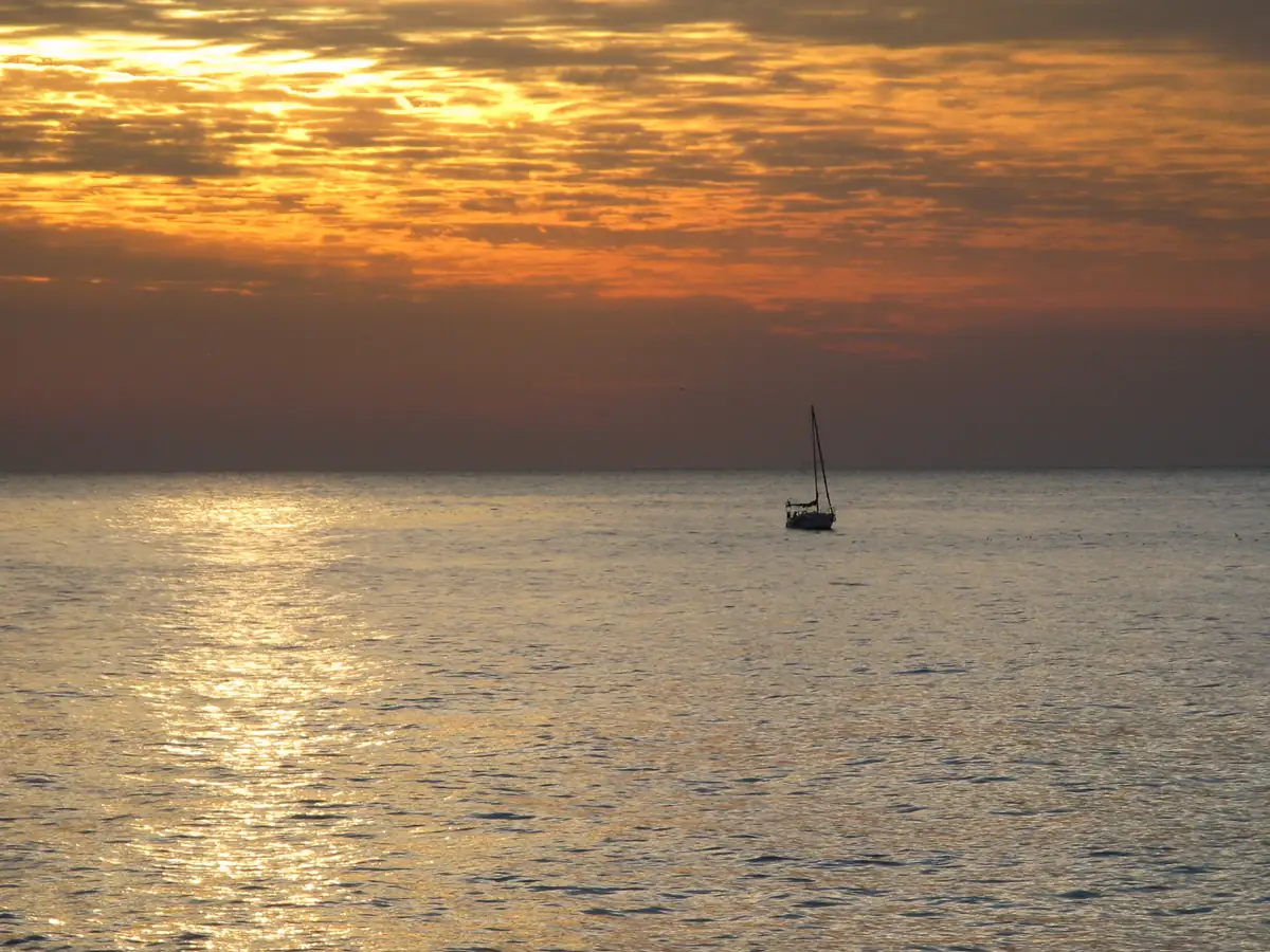 A sailboat on the sea off the Tel Aviv-Yafo beaches in golden light